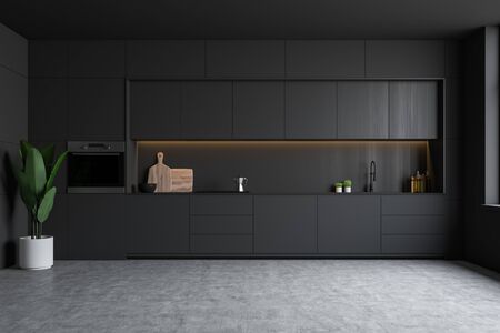 Interior of minimalist kitchen with dark grey walls, concrete floor, gray countertops with sink and...