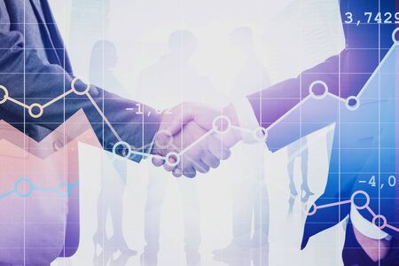 Close up of two businessmen shaking hands in city with double exposure of diagrams and business...
