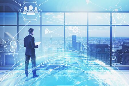 Businessman looking at city from panoramic office with double exposure of planet hologram and...