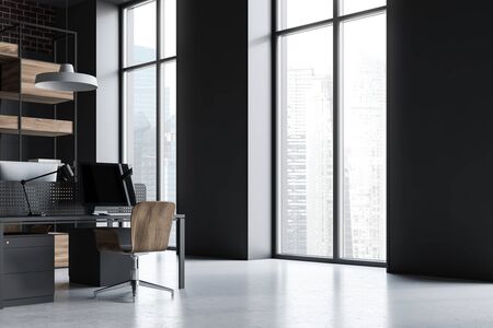 Comfortable workplace in modern office with gray walls, concrete floor, gray computer desk with wooden chair and bookcase. 3d renderingの写真素材