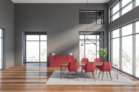Interior of luxury dining room with gray walls, wooden floor, grey carpet, long rectangular table with red chairs and red cabinet. 3d renderingの写真素材