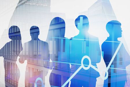 Silhouettes of business people over skyscraper background with double exposure of digital graph....