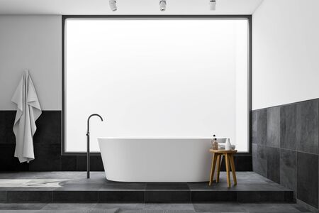 Interior of loft bathroom with white and tiled walls, tiled floor, comfortable bathtub and chair with towels and bottles. 3d renderingの写真素材