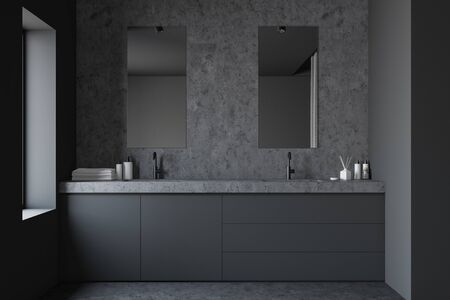 Interior of stylish bathroom with gray and stone walls, stone floor, double sink standing on grey countertop and two vertical mirrors. 3d renderingの写真素材