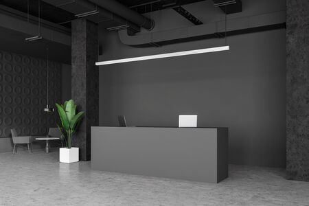 Interior of empty industrial style office with dark gray walls, concrete floor, grey reception desk and waiting room area with round table and comfortable armchairs. 3d renderingの写真素材