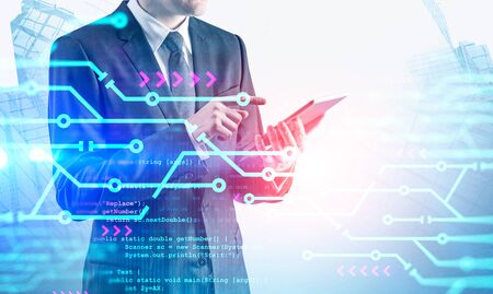 Unrecognizable man using tablet in city with double exposure of circuits and lines of code. Concept...