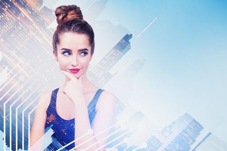 Pensive young woman in casual clothes standing in modern city with double exposure of network interface. Concept of hi tech and internet. Toned imageの写真素材