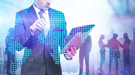 Businessman with clipboard working with digital world map in modern city with business people in background. Concept of international company and hi tech. Toned image double exposureの写真素材