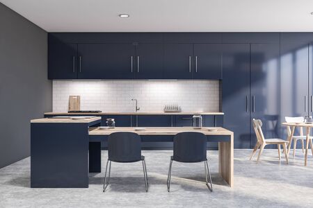 Interior of loft kitchen with gray and white brick walls, concrete floor, dark blue countertops and cupboards, round dining table with chairs and blue island. 3d renderingの写真素材