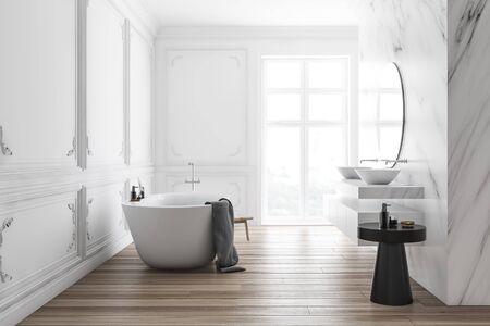 Interior of luxury bathroom with white and marble walls, comfortable white bathtub and double sink with round mirror above it. 3d renderingの写真素材