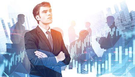 Handsome thoughtful confident businessman standing with crossed arms in city with double exposure of...
