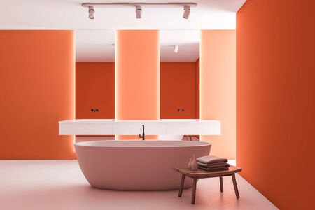 Interior of bright bathroom with orange walls, white floor, double sink with vertical mirrors, comfortable bathtub and chair with towels and beauty products. 3d renderingの写真素材