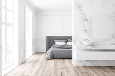 Interior of luxury classic style bedroom with white marble walls, wooden floor and comfortable king size bed. Bathroom with double sink and round mirror in foreground. 3d renderingの写真素材