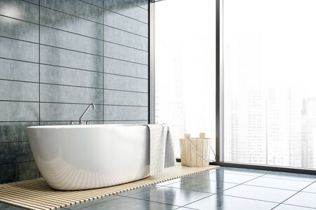 Corner of stylish bathroom with gray tile walls and floor, comfortable white bathtub and wooden bucket. Panoramic window with cityscape. Concept of spa. 3d renderingの写真素材