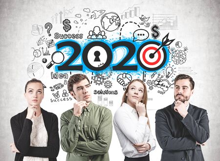 Thoughtful young business people standing near concrete wall with colorful 2020 strategy sketch....