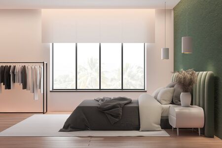 Side view of stylish master bedroom with green and pink walls, wooden floor, comfortable green king size bed with clothes hanging near it. 3d renderingの写真素材