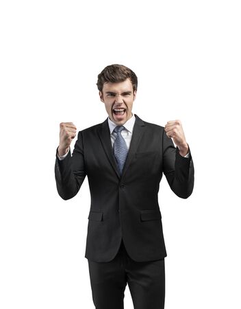 Isolated portrait of happy successful young businessman in suit shouting with clenched fists. Concept of business victory and celebration.の写真素材