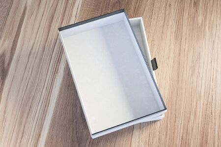 Top view of empty white and gray gift box lying on wooden table. Concept of holidays and...