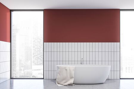 Interior of stylish bathroom with red and white tile walls, concrete floor, comfortable bathtub with towel and window with cityscape. 3d renderingの写真素材