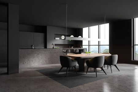 Corner of modern kitchen and dining room with dark grey walls, concrete floor, stone island with...