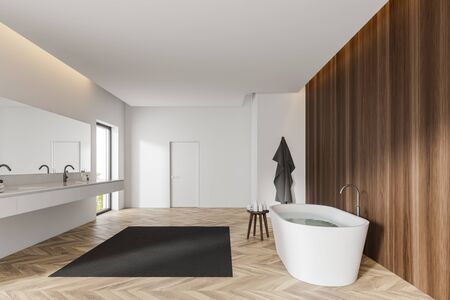 Interior of luxury bathroom with white and dark wooden walls, wooden floor, comfortable bathtub,...