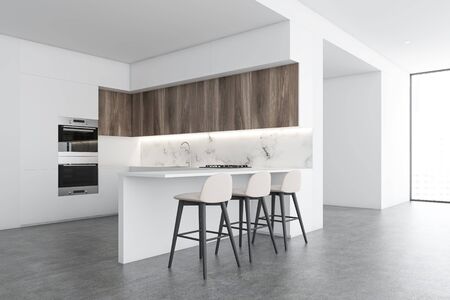 Corner of stylish kitchen with white and marble walls, concrete floor, white countertops, wooden...