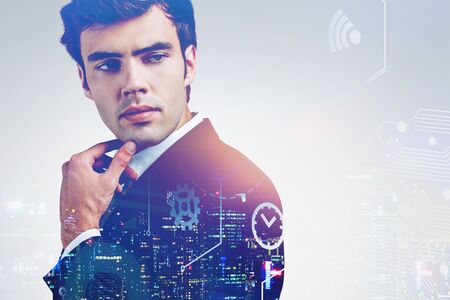 Pensive young businessman standing in night city with double exposure of internet of things...