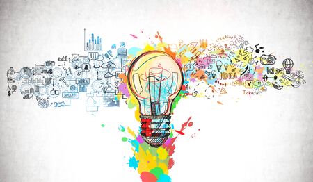 Creative and colorful light bulb sketch and business plan icons drawn on concrete wall. Concept of bright ideaの写真素材