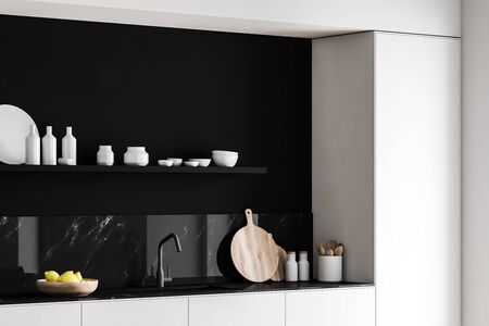 Corner of modern kitchen with black marble walls, white countertops with built in sink and cutting boards and shelf with dishes and bottles above it. 3d renderingの写真素材