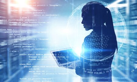 Silhouette of beautiful young engineer with laptop working in blurry data center with double...