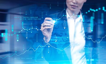 Unrecognizable businesswoman working with futuristic financial chart interface in blurry office....