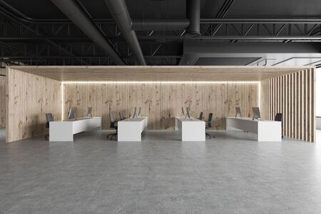 Interior of stylish industrial style open space office with wooden walls, concrete floor and row of...