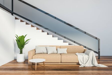 Interior of minimalistic living room with white walls, wooden floor, beige sofa standing near staircase and round coffee table. 3d renderingの写真素材