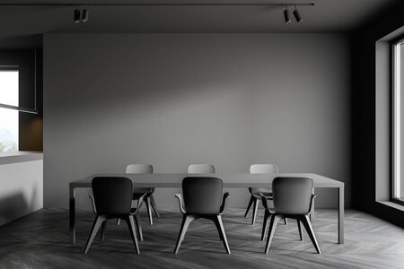 Interior of minimalistic dining room with grey walls, dark wooden floor, gray table with chairs and...