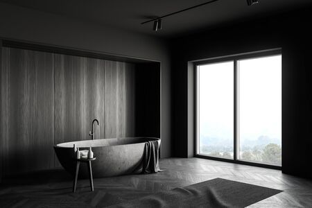 Corner of modern bathroom with grey and dark wooden walls, comfortable stone bathtub and chair with...