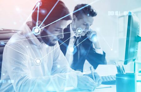 Two young businessmen working together in blurry office with double exposure of creative futuristic...