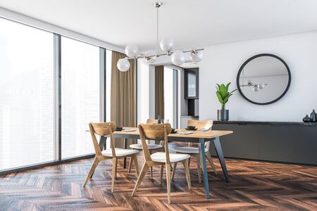 Corner of minimalistic dining room with white walls, dark wooden floor, dining table with wooden...