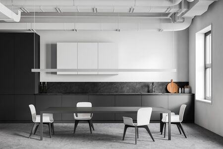 Interior of industrial style kitchen with white and grey walls, concrete floor, gray countertops with built in appliances, white cupboards and long dining table with white chairs. 3d renderingの写真素材