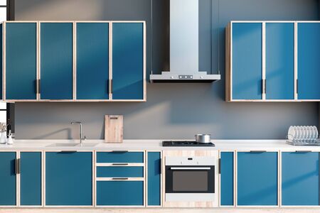 Close up of blue countertops with built in sink and cooker and cozy cupboards above them in modern kitchen interior with grey walls. 3d renderingの写真素材