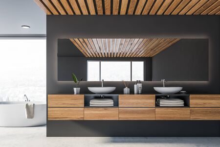 Comfortable double sink on wooden countertop standing in panoramic bathroom with grey walls, wooden ceiling and white bathtub near panoramic window with blurry view. 3d renderingの写真素材