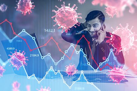 Stressed young businessman sitting in blurry office and panicking because of economical crisis due to coronavirus pandemic. Toned image double exposureの写真素材