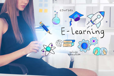 Unrecognizable young woman using tablet in blurry room with double exposure of creative e learning sketch. Concept of online education during covid 19 pandemic. Toned imageの写真素材