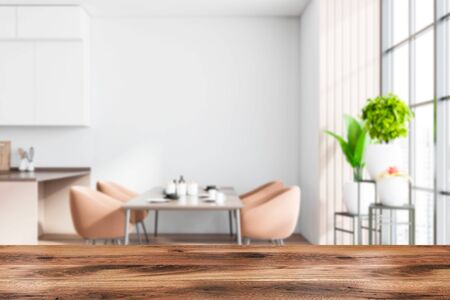 Wooden table for your product in blurry stylish dining room with white walls, long dining table with beige armchairs and plants on shelves near window. 3d rendering mock upの写真素材