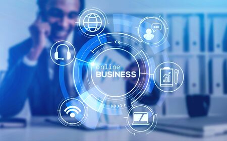 Blurry smiling African American businessman talking on smartphone in blurry room with double exposure of creative futuristic immersive hud online business interface. Toned imageの写真素材
