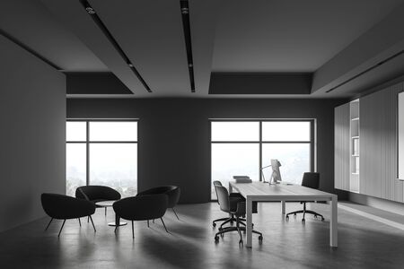 Interior of modern CEO office with grey walls, concrete floor, comfortable computer table with...