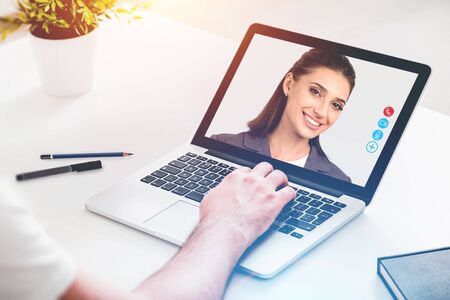 Businessman and young businesswoman making video call with laptop at blurry table. Concept of communication and technology. Video conference. Toned imageの写真素材