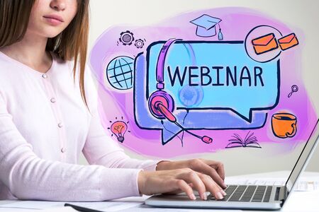 Unrecognizable young European businesswoman typing on laptop with double exposure of colorful webinar sketch. Concept of e learningの写真素材