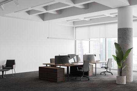 Corner of stylish panoramic open space office with white walls, carpeted floor, row of wooden computer tables and lounge area with armchairs. Blurry cityscape. 3d renderingの写真素材