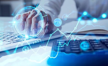 Businesswoman typing on laptop in blurry office with double exposure of financial interface. Concept...