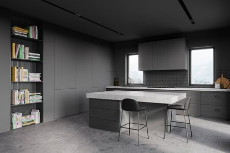 Corner of stylish kitchen with gray and tiled walls, concrete floor, countertops, bookcase, bar with stools and windows with blurry mountain view. 3d renderingの写真素材